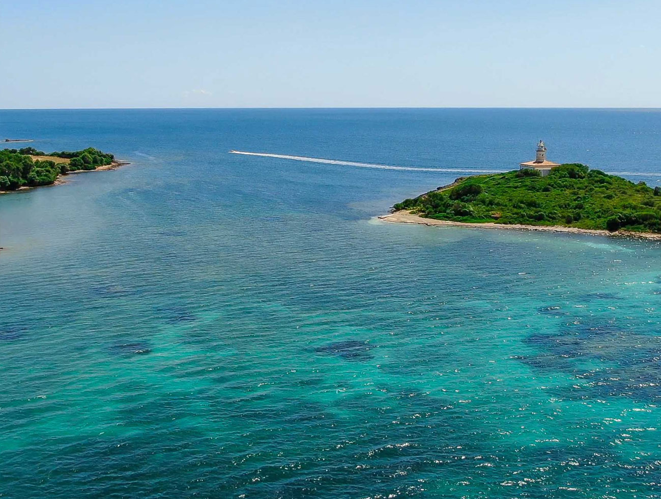Alcanada lighthouse and crystal clear water Alcudia
